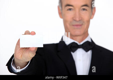 Silver service waiter holding up a business card Stock Photo