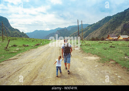 father and daughter go camping on the road near the mountains Stock Photo