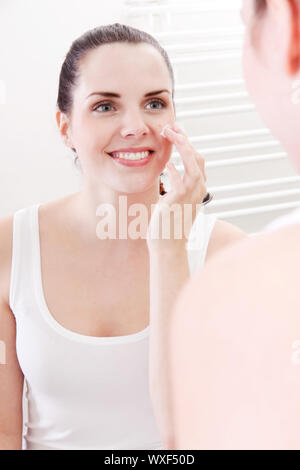 apllying cream on face skincare Stock Photo