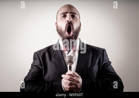 funny elegant singer bearded on vignetting background Stock Photo