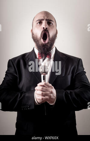 funny elegant singer bearded on vignetting background Stock Photo