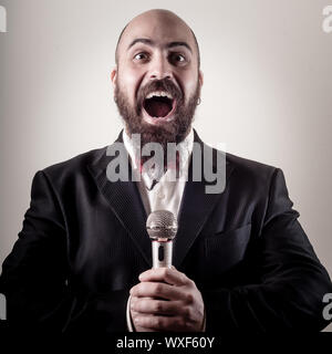 funny elegant singer bearded on vignetting background Stock Photo