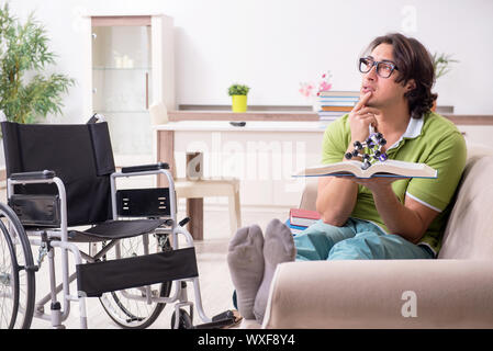 Young male student in wheelchair at home Stock Photo