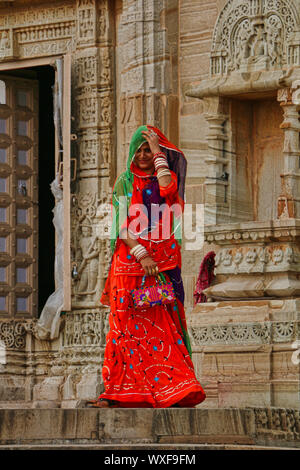 Image of Two veiled women in traditional, colourful Rajasthani dress, one  holding
