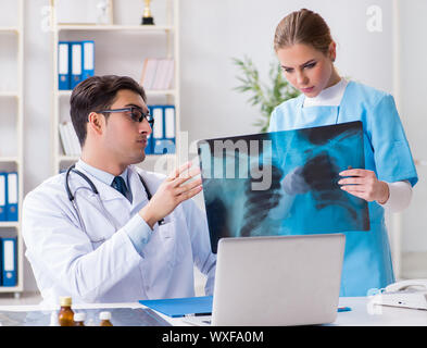 Two doctors examining x-ray images of patient for diagnosis Stock Photo