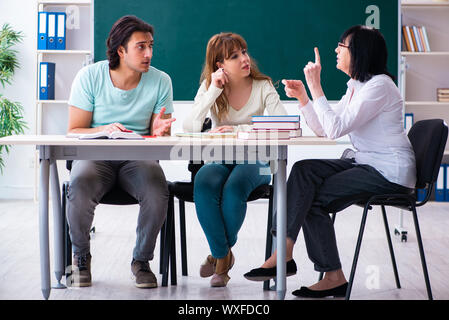 Old teacher and students in the classroom Stock Photo