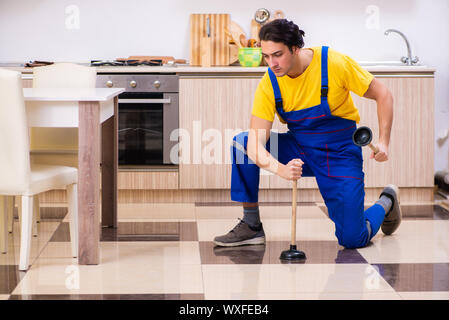 Young male contractor repairing tap at home Stock Photo