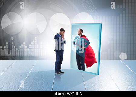 Businessman seeing himself in mirror as superhero Stock Photo