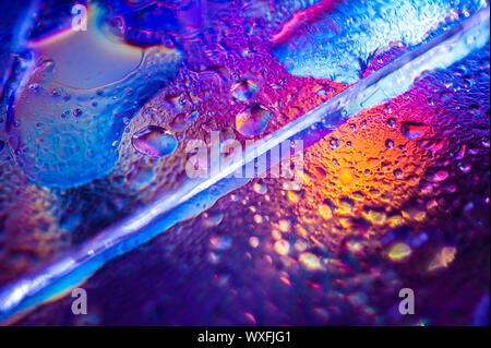 Background in the style of the 80-90s. Real texture of broken glass or ice and drops in bright acid colors. Stock Photo