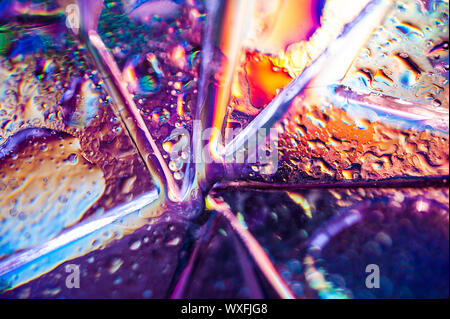 Background in the style of the 80-90s. Real texture of broken glass or ice and drops in bright acid colors. Stock Photo