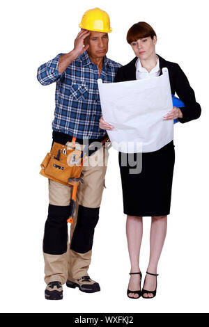 Tradesman looking at a blueprint Stock Photo - Alamy
