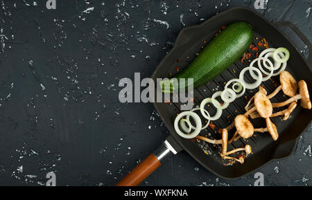 Fresh mushrooms with spices and herbs on black board. View from above. Copy space. Stock Photo