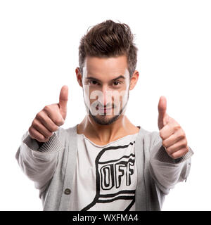 Casual portrait of a young man with thumbs up, over a gray background Stock Photo