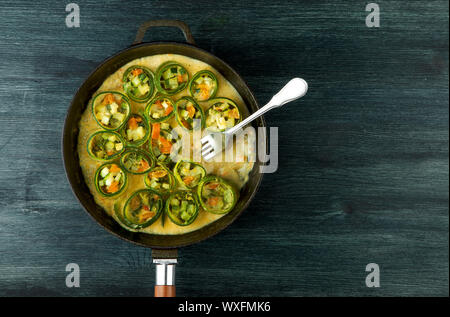 Zucchini in the background. Fried young sliced courgettes in a pan on a dark background. The view from the top. Copy space Stock Photo