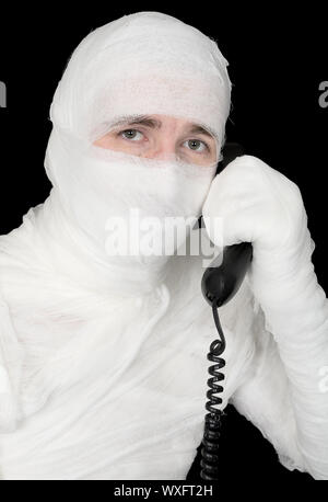 Mummy-businessman talking on telephone on the black background Stock Photo