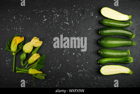 Fresh green zucchini on a dark table. The view from the top. Copy space. Stock Photo