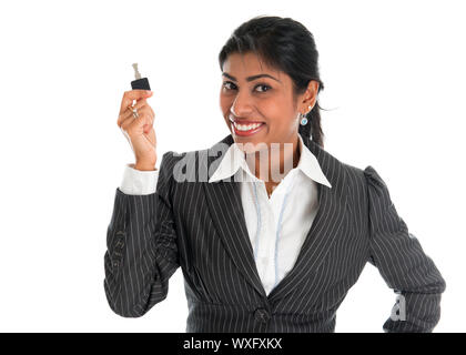 Estate agent. Happy Indian business woman or realtor showing keys. Isolated over white background. Stock Photo