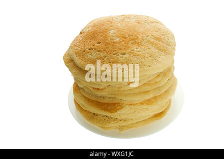 Pancakes on a plate isolate. A large stack of lush rosy pancakes on a white plate on an isolated surface. Stock Photo