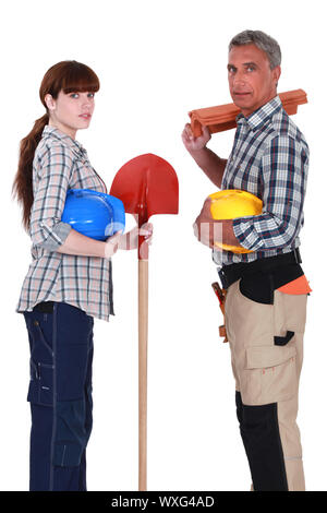 Male and female roofers stood together Stock Photo