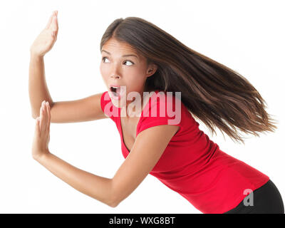 Woman pushing with great strength or protecting herself from something. Isolated on white background. Stock Photo