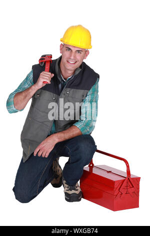 Smiling plumber with his toolbox on white background Stock Photo