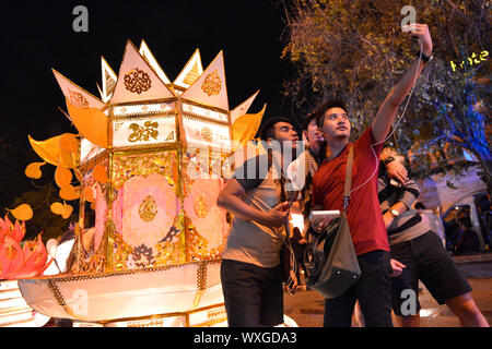 A group of young men celebrating the annual festival Loi Krathong and making a selfie in front of a huge lantern representing a traditional Krathong. Chiang Mai, Chiang Mia Province, Northern Thailand, Thailand, Southeast Asia, Asia Stock Photo