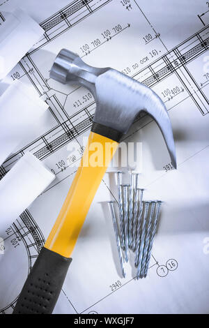 Claw hammer and nails with blueprints Stock Photo - Alamy