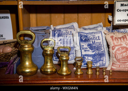 UK, County Durham, Beamish, Museum, Town, Annfield Plain Industrial Co-Op shop, provisions department, shelf of flour bags with graduated brass weight Stock Photo