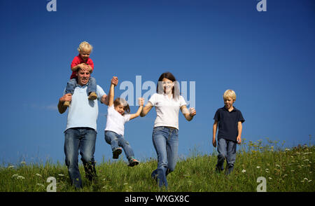 Family walking in field playing with children. Stock Photo