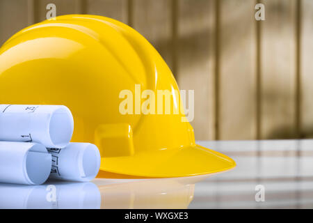 blueprints and yellow helmet on white table Stock Photo