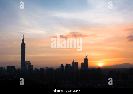 Sunset cityscape with silhouette of 101 skyscraper under dramatic clouds in orange and yellow color in Taipei, Taiwan, Asia. Stock Photo