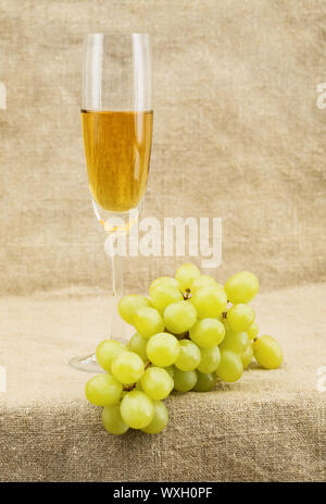 Still-life with a glass of wine and grapes on sacking background Stock Photo