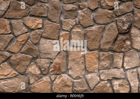 Abstract stone wall background. Natural pattern. Copy space. Rock texture. Decorative tile. Vintage floor. Old brown cement surface. Stock Photo