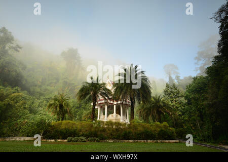 A Buddhist shrine in the morning fog. Wat Tham Pha Plong monastery, Chiang Dao, Chiang Mai Province, Thailand. Stock Photo