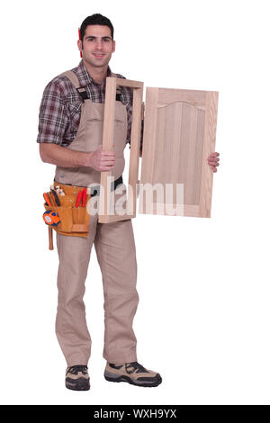 carpenter holding a wooden window frame Stock Photo