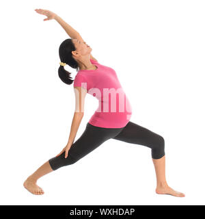 Prenatal yoga class. Full length healthy Asian pregnant woman doing yoga exercise stretching at home, fullbody isolated on white background. Stock Photo