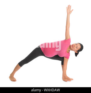 Prenatal yoga class. Full length healthy Asian pregnant woman doing yoga exercise stretching at home, fullbody isolated on white background. Yoga posi Stock Photo