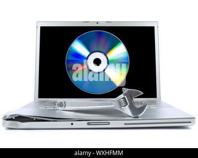 Damaged laptop with a spanner over it and a digital disc on the screen. Isolated on white. Stock Photo