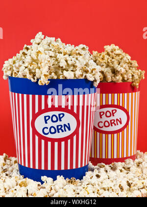 Two popcorn buckets over a red background. Stock Photo
