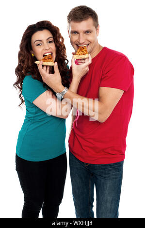 Adorable love couple enjoying pizza pie together. Both making each other enjoy pizza piece Stock Photo