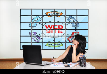 woman in office looking at plasma with web site scheme Stock Photo