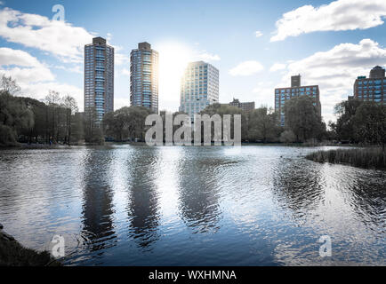 A shot of Central Park during a beautiful sunny day, with buildings reflecting into the water of a lake. New York City, United States Stock Photo
