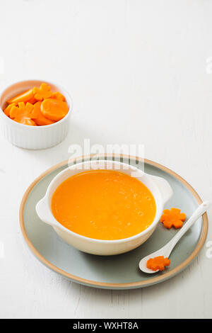 Carrot baby puree in bowl isolated on light background Stock Photo