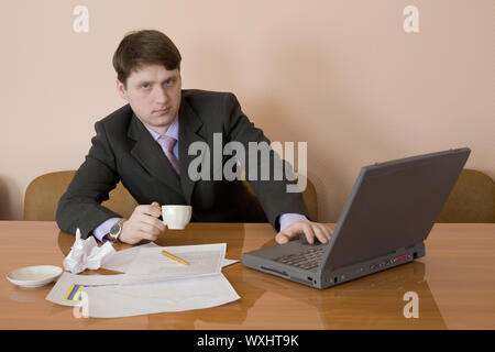Businessman on a workplace with the laptop and a coffee cup Stock Photo