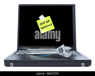 Laptop with an Out of Service sticky note and a spanner over the keyboard. Isolated on white. Stock Photo