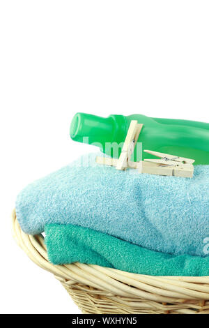 Laundry basket with fresh towels, laundry soap and clothespins isolated on white. Stock Photo
