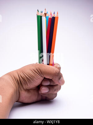 Hand holding bunch of colored pencils together. Stock Photo