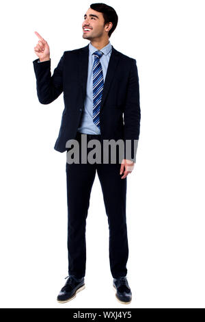 Young executive indicating and looking upwards isolate on white Stock ...