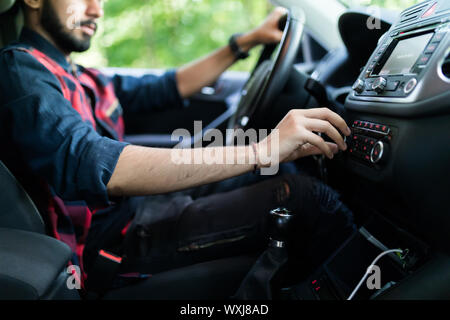 transportation and vehicle concept - man using car audio stereo system Stock Photo