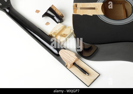 Guitar repair and service - Fragment broken sound board and neck acoustic guitar white background Stock Photo